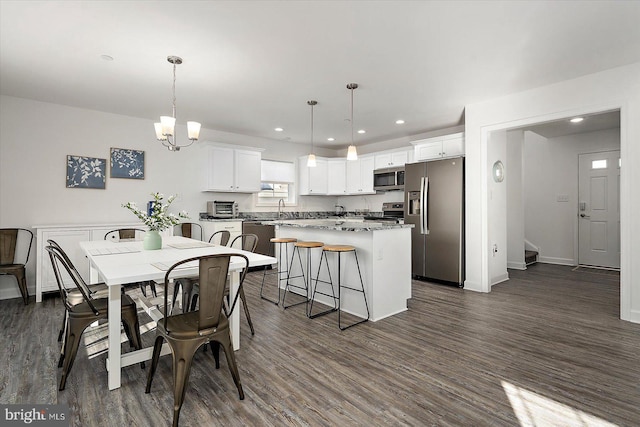 dining area with dark hardwood / wood-style flooring, sink, and an inviting chandelier