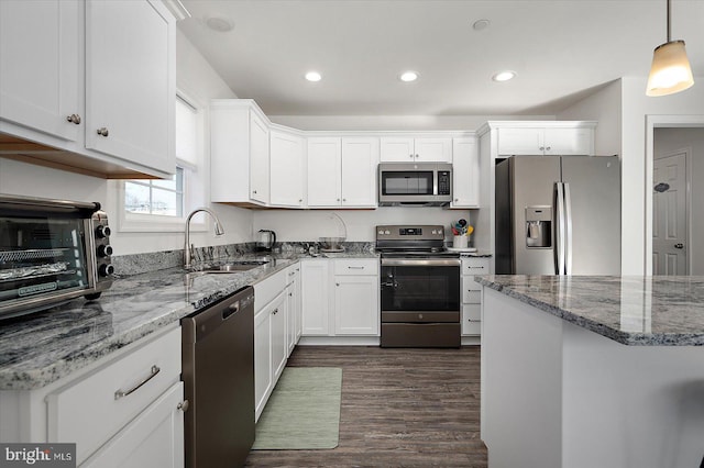 kitchen featuring hanging light fixtures, white cabinetry, appliances with stainless steel finishes, and sink