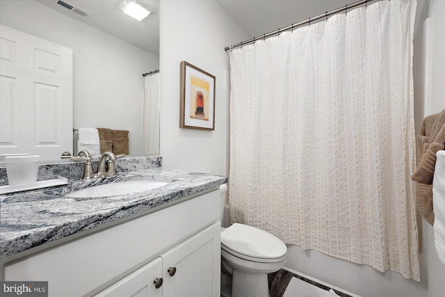 full bathroom with vanity, shower / tub combo, and toilet