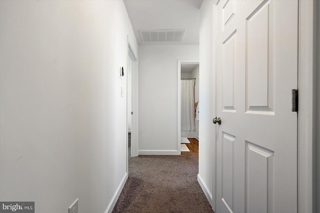 corridor featuring dark colored carpet