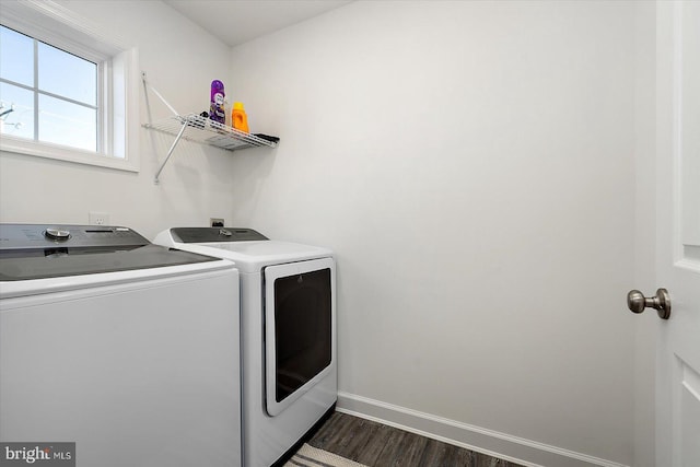 clothes washing area with dark wood-type flooring and washer and clothes dryer