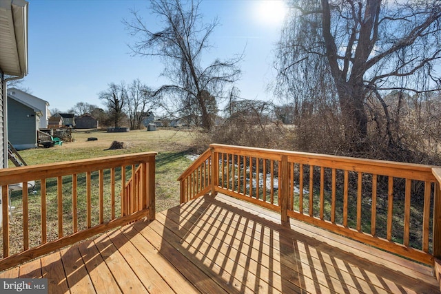 wooden terrace featuring a lawn