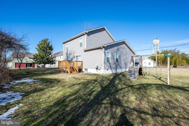 rear view of property with a yard, a deck, and a playground