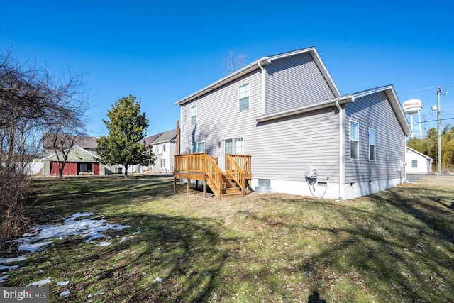 back of house featuring a wooden deck and a lawn