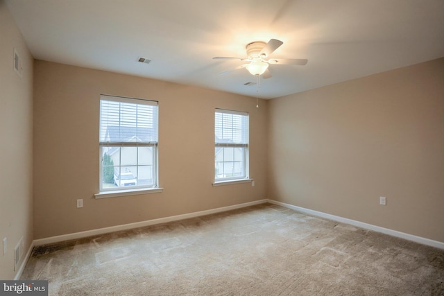 spare room featuring light carpet and ceiling fan