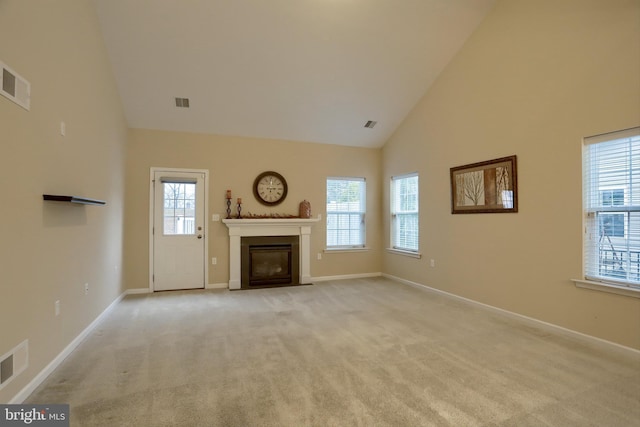 unfurnished living room featuring light colored carpet and high vaulted ceiling