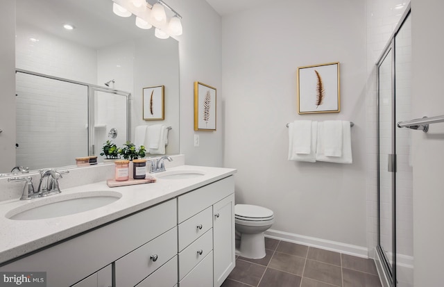 bathroom with vanity, toilet, tile patterned flooring, and a shower with door