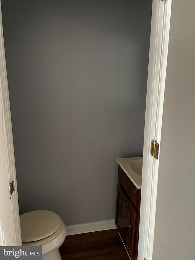 bathroom featuring vanity, toilet, and hardwood / wood-style floors