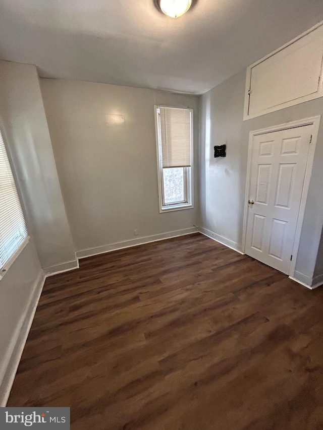 unfurnished room with dark hardwood / wood-style flooring