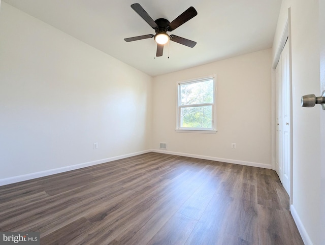 spare room featuring dark hardwood / wood-style flooring and ceiling fan