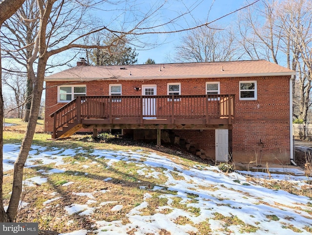 snow covered house with a wooden deck