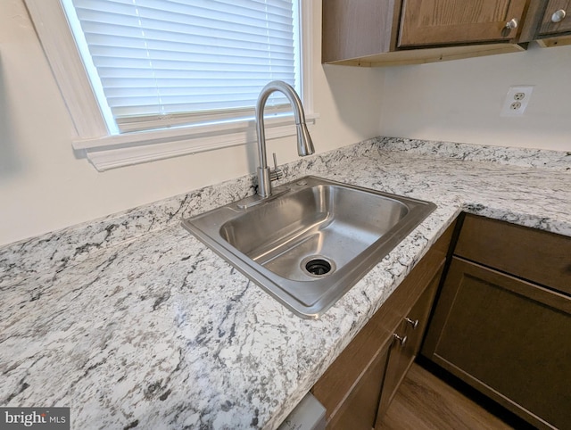 details featuring light stone countertops and sink