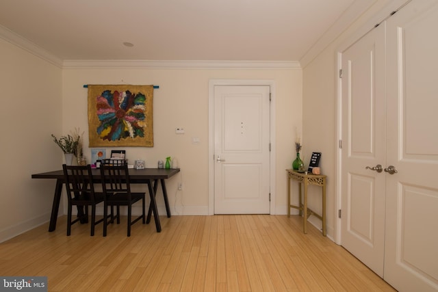 dining room with ornamental molding and light hardwood / wood-style flooring