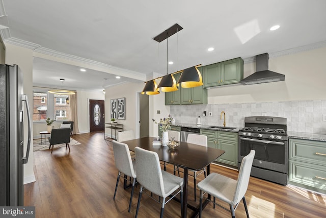 dining area featuring sink, ornamental molding, and hardwood / wood-style floors