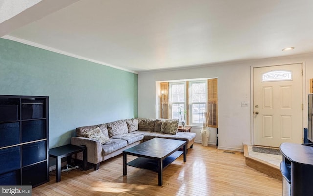 living room with ornamental molding and light wood-type flooring