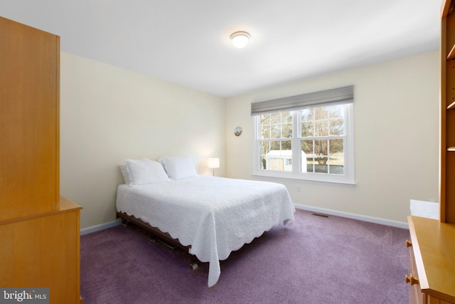 bedroom featuring visible vents, dark carpet, and baseboards