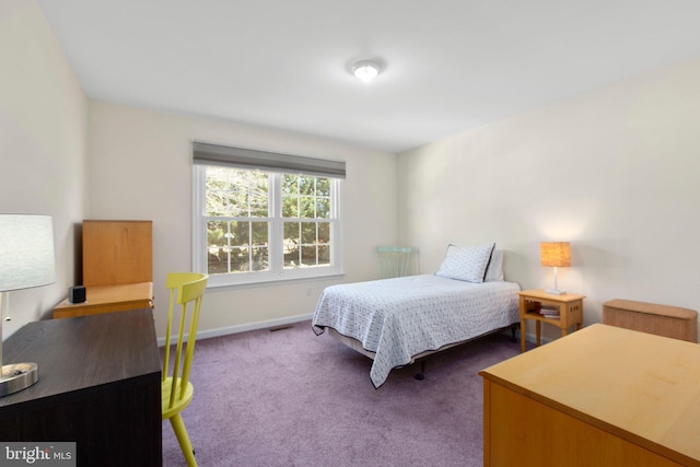 bedroom with dark colored carpet, visible vents, and baseboards