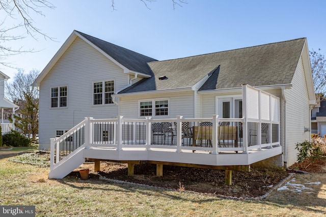 rear view of property with a wooden deck and a shingled roof