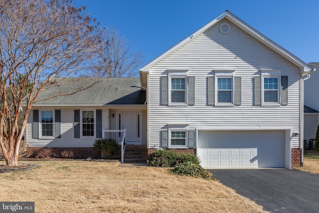 tri-level home with a garage, a front lawn, and driveway