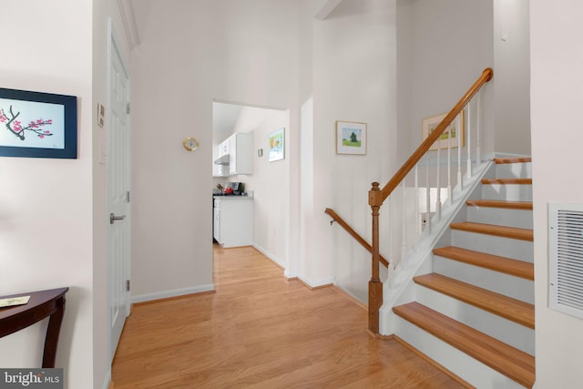 interior space with a high ceiling, wood finished floors, and baseboards