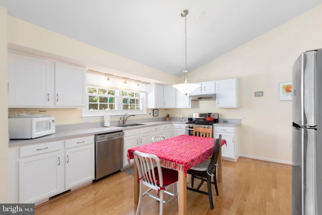 kitchen with decorative light fixtures, light countertops, appliances with stainless steel finishes, white cabinets, and a sink