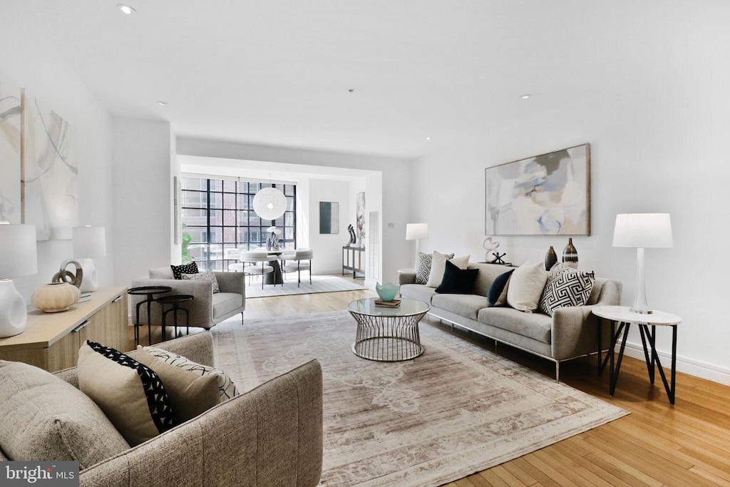 living room with baseboards, wood finished floors, and recessed lighting