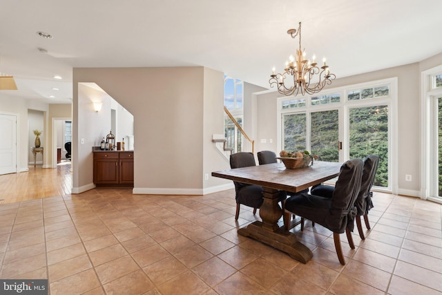 tiled dining room with a chandelier