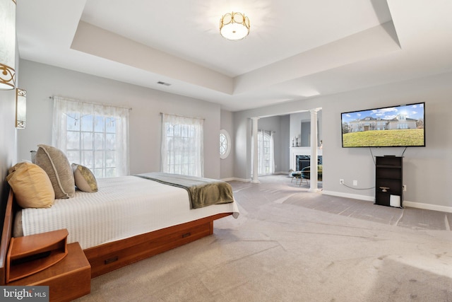 carpeted bedroom with a tray ceiling