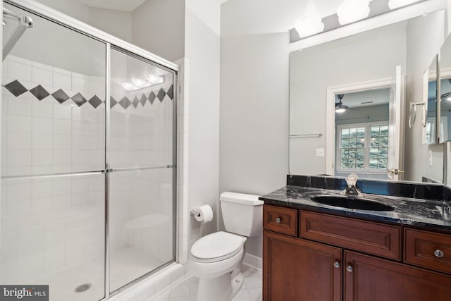 bathroom with vanity, a shower with shower door, tile patterned floors, and toilet