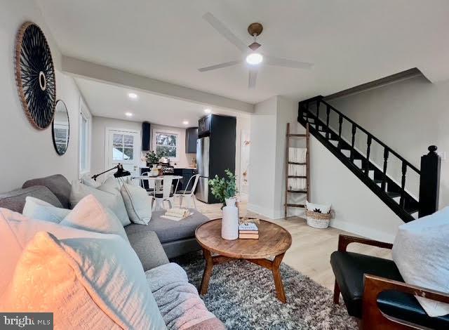 living room featuring ceiling fan and light wood-type flooring