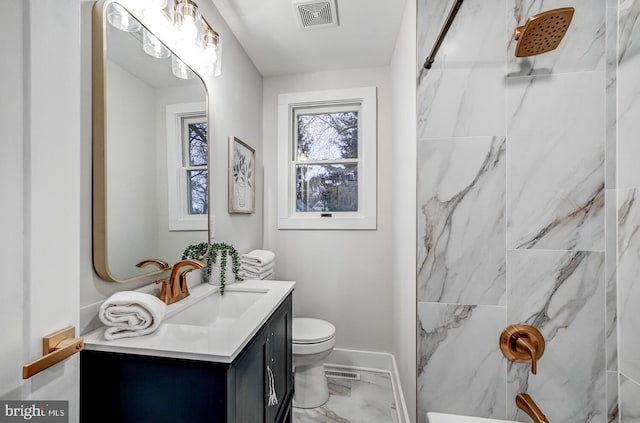 bathroom featuring tiled shower, vanity, and toilet