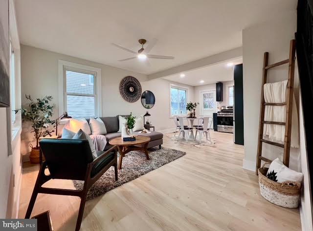 living room featuring ceiling fan and light wood-type flooring