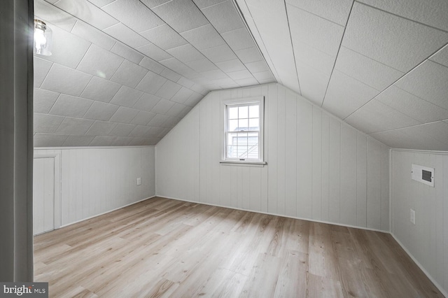 bonus room with lofted ceiling and light hardwood / wood-style flooring