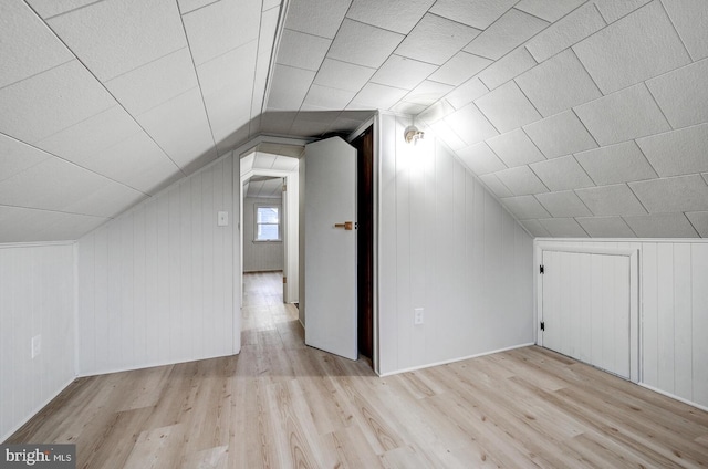 bonus room with vaulted ceiling and light hardwood / wood-style floors