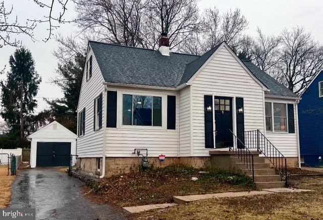 view of front of property featuring a garage and an outdoor structure