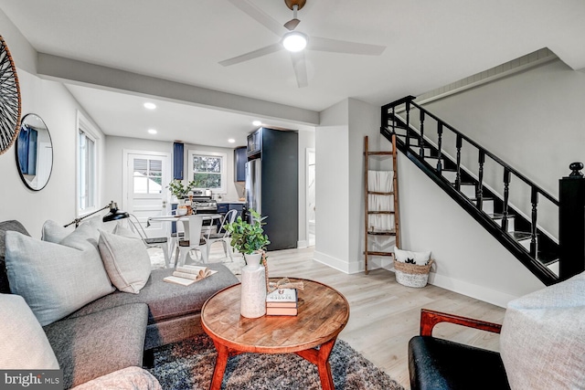 living room featuring ceiling fan and light hardwood / wood-style flooring