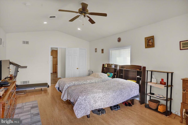 bedroom featuring lofted ceiling, white fridge, ceiling fan, and light wood-type flooring