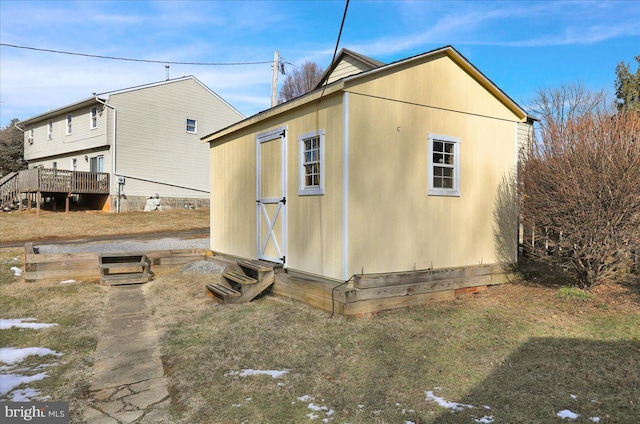 view of side of property with a deck and a shed