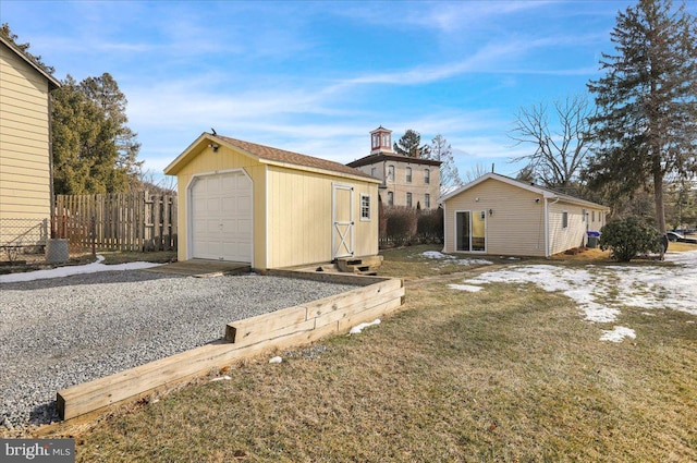 exterior space featuring a garage, a yard, and an outbuilding