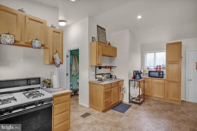 kitchen with sink, range with gas cooktop, and light brown cabinets