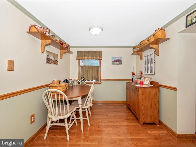 dining room featuring crown molding and light wood-type flooring