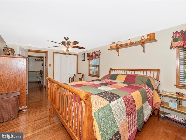 bedroom with hardwood / wood-style floors, ceiling fan, and a closet