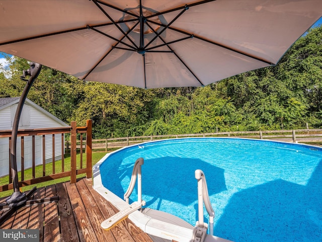 view of swimming pool with an outbuilding and a deck