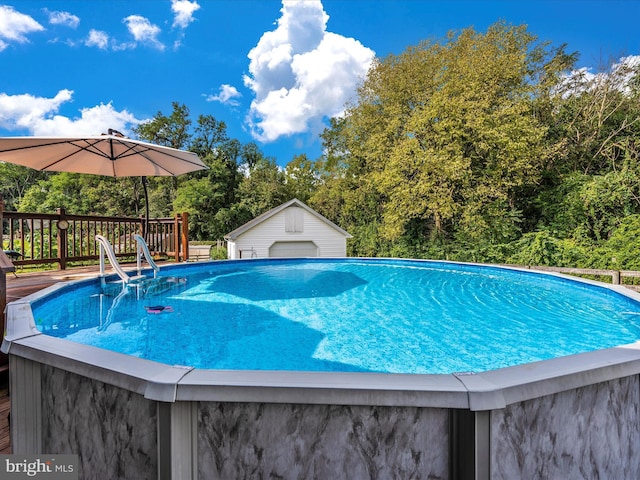 view of pool with an outbuilding and a deck