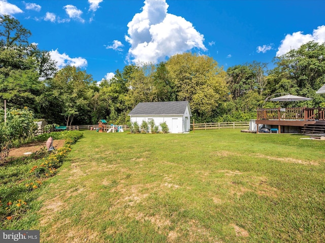 view of yard featuring a deck, a shed, and a playground