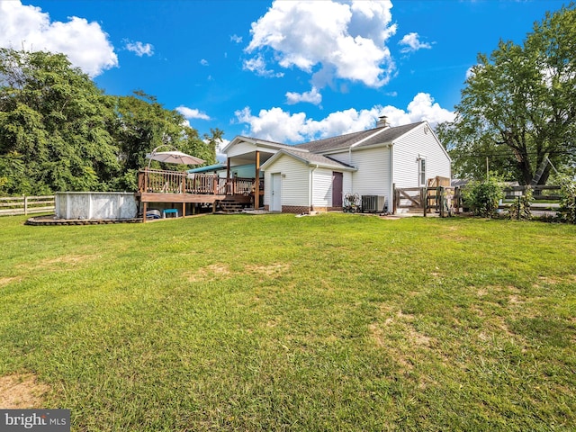 back of house featuring a pool side deck, central AC unit, and a lawn