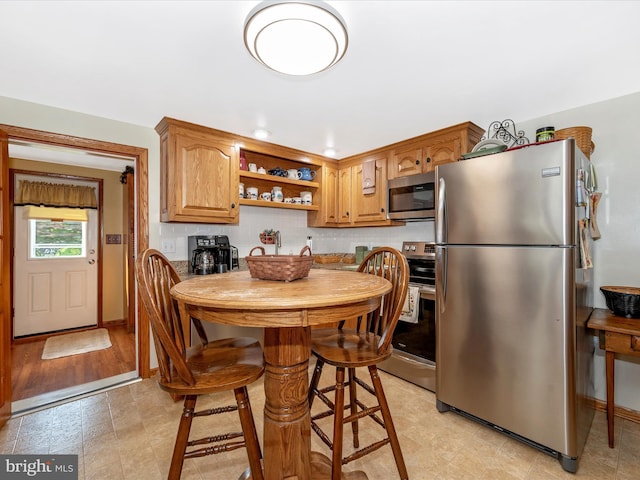 kitchen featuring decorative backsplash, stainless steel appliances, and a breakfast bar