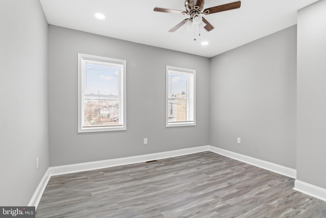 empty room with ceiling fan and light hardwood / wood-style flooring