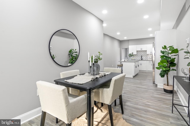 dining area with sink and light hardwood / wood-style flooring