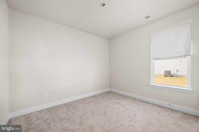 spare room featuring light colored carpet